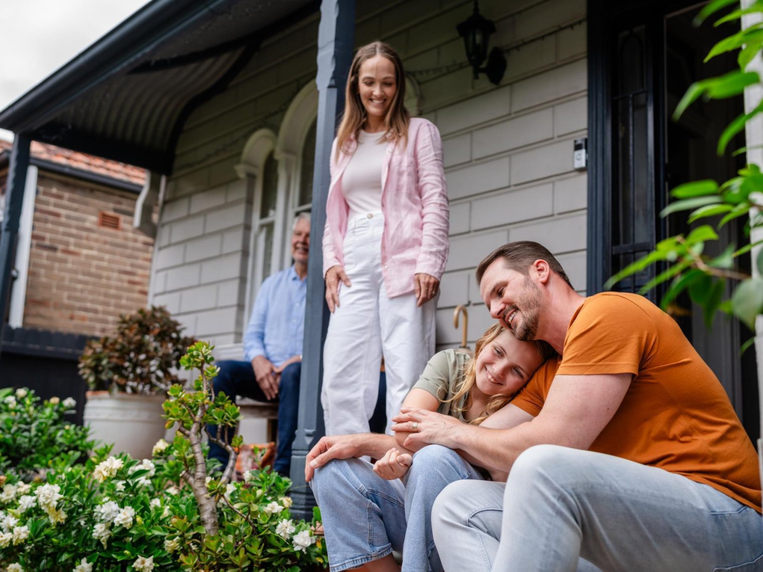 A family spending time together on the porch of their new home.