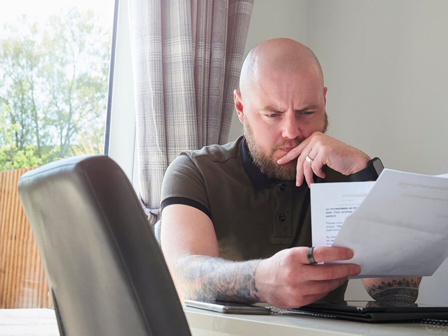 Man contemplating debt paperwork.