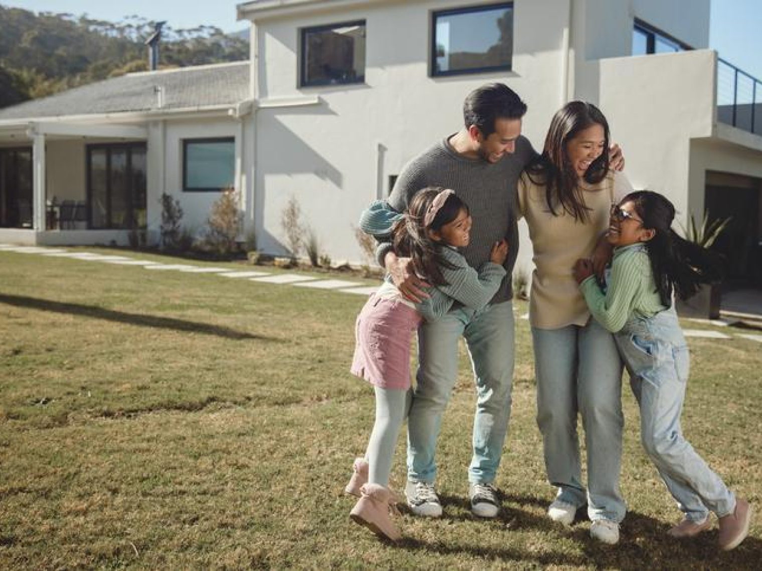A family enjoying time outside their home they just refinanced.