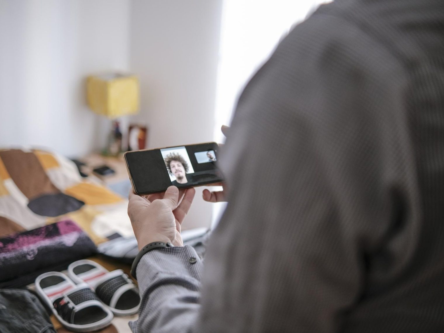 Overseas service member video chatting with loan officer. A packed, open suitcase can be seen in the background.